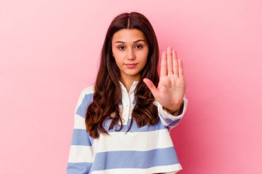 Pembe arka planda izole edilmiş genç Hintli kadın elini uzatmış, dur işareti göstererek seni engelliyor..