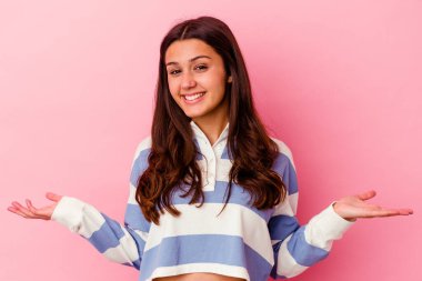 Pembe arka planda izole edilmiş genç Hintli kadın hoş bir yüz ifadesi sergiliyor..