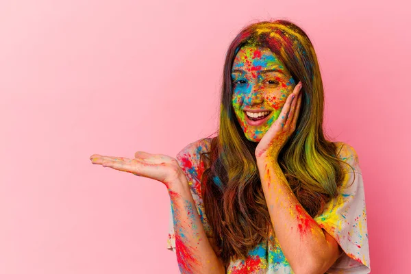 Beyaz arka planda izole edilmiş kutsal festivali kutlayan genç Hintli kadın avuç içinde fotokopi alanı tutuyor, el üstünde tutuyor. Şaşırmış ve mutlu..