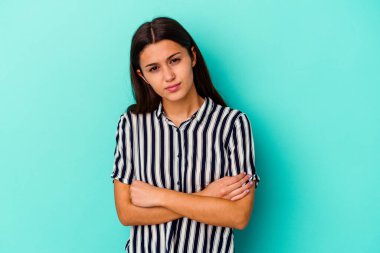 Mavi arka planda izole edilmiş genç Hintli kadın şüpheli, belirsiz, seni muayene ediyor..