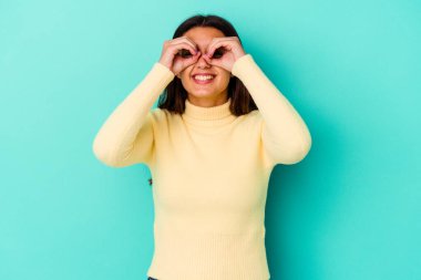 Mavi arka planda izole edilmiş genç Hintli kadın gözlerinde sorun olmadığını gösteriyor.