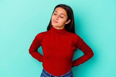 Genç Hintli kadın mavi arka planda izole edilmiş amaçlara ve amaçlara ulaşmayı hayal ediyor.