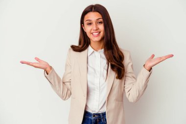 Beyaz arka planda izole edilmiş genç Hintli iş kadını kollarıyla ölçeği yapıyor, mutlu ve kendinden emin hissediyor..