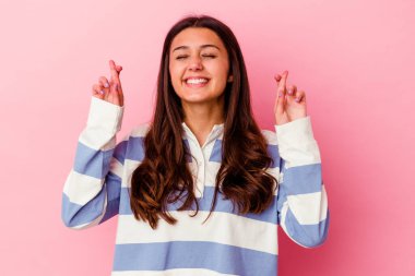 Pembe arka planda izole edilmiş genç Hintli kadın şans dilemek için şans diliyor.