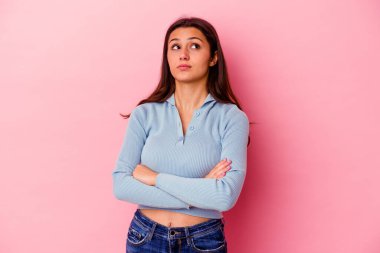 Pembe arka planda izole edilmiş genç Hintli kadın tekrarlanan bir görevden yoruldu..