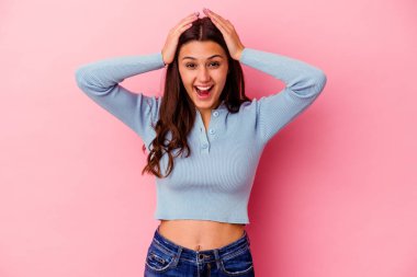 Genç Hintli kadın pembe arka planda izole edilmiş bağırıyor, çok heyecanlı, tutkulu, bir şeyden memnun..