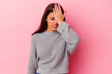 Pembe arka planda izole edilmiş genç Hintli kadın bir şeyi unutuyor. Alnına avuç içi ve gözlerini kapatarak vuruyor..