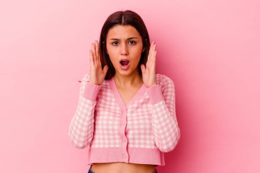 Pembe arka planda yaşayan genç Hintli kadın şaşırdı ve şok oldu..