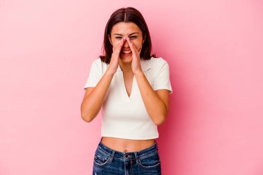 Pembe arka planda izole edilmiş genç Hintli bir kadın bir dedikodu söylüyor, bir haber sunuyor..