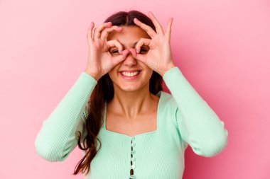 Pembe arka planda izole edilmiş genç Hintli kadın heyecanlı..