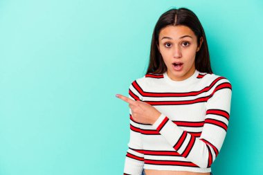 Mavi arka planda izole edilmiş genç Hintli kadın...