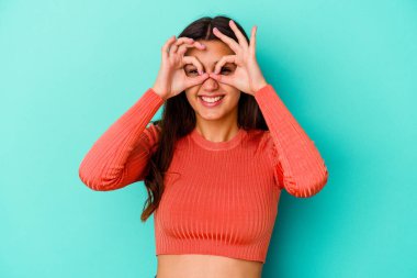 Mavi arka planda izole edilmiş genç Hintli kadın gözlerinde sorun olmadığını gösteriyor.