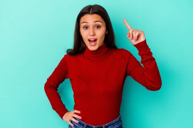 Genç Hintli bir kadın mavi arka planda izole edilmiş. Harika bir fikri var. Yaratıcılık kavramı..