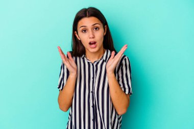 Mavi arka planda yalnız yaşayan genç Hintli kadın şaşırdı ve şok oldu..