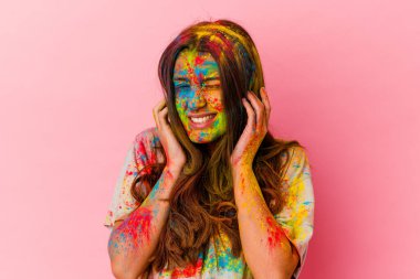 Genç Hintli kadın kutsal festivali kutluyor. Beyaz arka planda izole edilmiş kulakları elleriyle kapatıyor..