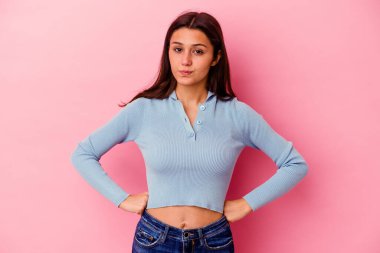 Pembe arka planda izole edilmiş genç Hintli kadın yanakları patlatıyor, yorgun bir ifadesi var. Yüz ifadesi kavramı.