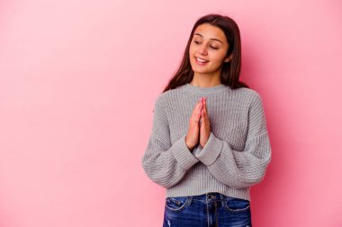 Pembe arka planda izole edilmiş genç Hintli bir kadın..