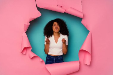 Kırık kağıda sarılı genç Afrikalı Amerikalı kadın mavi arka planda izole edilmiş, parası olmadığını gösteriyor..