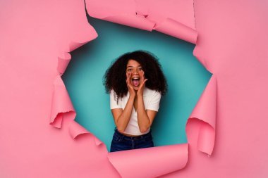 Genç Afrikalı Amerikalı yırtık bir kadın mavi arka planda izole edilmiş, heyecanlı bir şekilde bağırıyor..