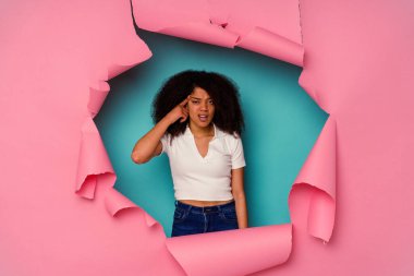 Genç Afrikalı Amerikalı yırtık bir kadın mavi arka planda izole edilmiş işaret parmağıyla hayal kırıklığı gösteren bir jest yapıyor..