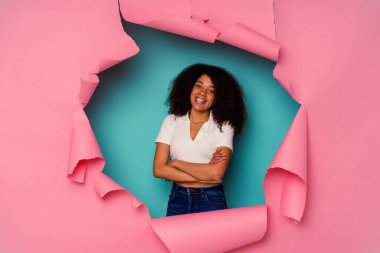 Genç Afrikalı Amerikalı yırtık bir kadın mavi arka planda izole edilmiş, kendinden emin, kararlılıkla kollarını kavuşturuyor..