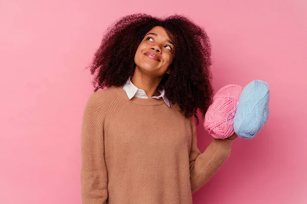 一个年轻的非洲裔美国女人 手里拿着一根用粉色背景隔开的缝纫线 梦想着实现自己的目标和目的 — 图库照片