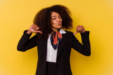 Sarı arka planda izole edilmiş genç Afrikalı Amerikalı hostes kendini gururlu ve kendinden emin hissediyor..