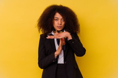 Genç Afrikalı Amerikalı hostes sarı arka planda izole edilmiş bir şekilde mola veriyor..