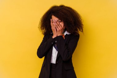 Genç Afrikalı Amerikalı hostes sarı arka planda izole edilmiş. Korkmuş ve gergin parmaklarıyla göz kırp..