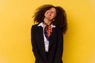 Genç Afrikalı Amerikalı hostes sarı arka planda izole edilmiş hedeflerine ve amaçlarına ulaşma hayali kuruyor.