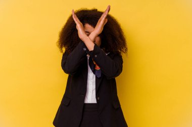 Genç Afrikalı Amerikalı hostes sarı arka planda izole edilmiş iki kolu çapraz tutuyor, inkar kavramı.