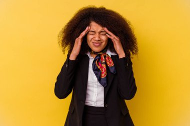 Genç Afrikalı Amerikalı hostes sarı arka planda izole edilmiş tapınaklara dokunuyor ve baş ağrısı çekiyor..