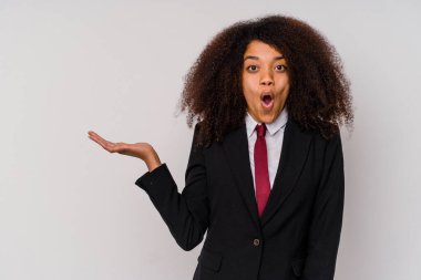 Beyaz arka planda izole edilmiş takım elbiseli genç Afrikalı Amerikalı iş kadını avuç içi fotokopi alanını tutmaktan etkilenmiş..