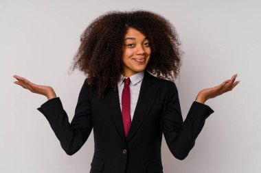 Beyaz arka planda soyutlanmış takım elbiseli genç Afrikalı Amerikalı iş kadını sorgulama sırasında omuz silkiyor ve şüphe ediyordu..