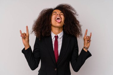 Beyaz arka planda izole edilmiş takım elbiseli genç Afrikalı Amerikalı iş kadını parmaklarıyla kaya hareketi gösteriyor.