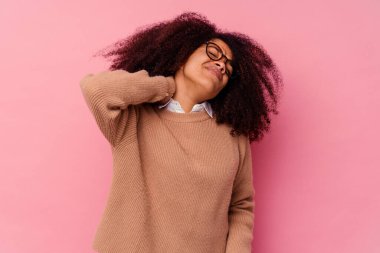 Genç Afrikalı Amerikalı bir kadın pembe arka planda izole edilmiş, sabit yaşam tarzından dolayı boyun ağrısı çekiyor..