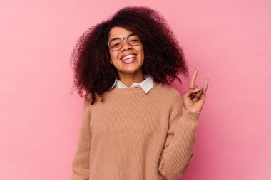 Pembe arka planda izole edilmiş genç Afrikalı Amerikalı kadın boynuzlarını devrim konsepti olarak gösteriyor..