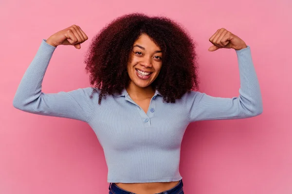 年轻的非洲裔美国女人 背景是粉色的 以双臂展示力量 象征着女性的力量 — 图库照片