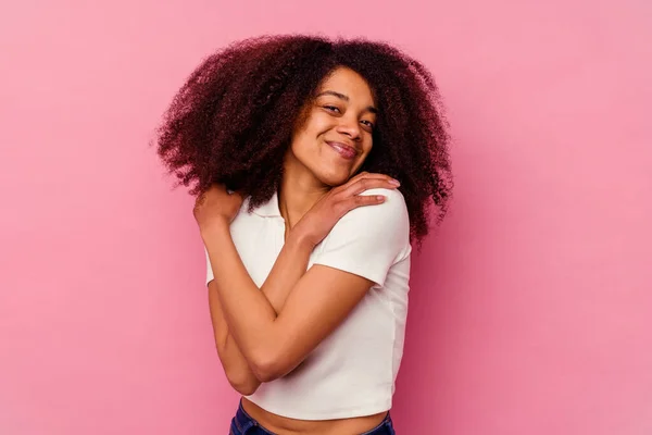 年轻的非洲裔美国女人 与粉红的背景拥抱在一起 无忧无虑 快乐地微笑着 — 图库照片