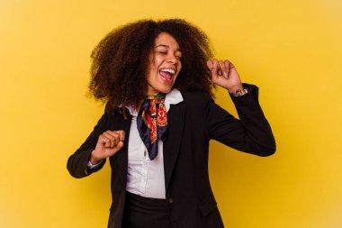 Genç Afrikalı Amerikalı hostes sarı arka planda dans ediyor ve eğleniyor..