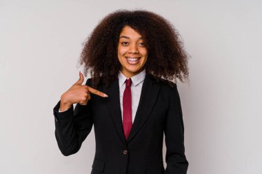 Beyaz arka planda izole edilmiş takım elbiseli genç Afro-Amerikalı bir iş kadını gömlek fotokopi alanını elle gösteriyor, gururlu ve kendinden emin.