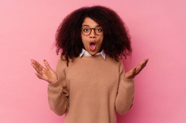 Genç Afrikalı Amerikalı kadın pembe arka planda izole edilmiş şaşırmış ve şok olmuş..