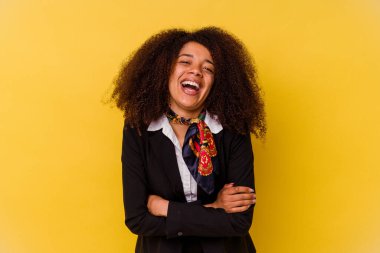 Genç Afrikalı Amerikalı hostes sarı arka planda izole edilmiş gülüyor ve eğleniyor..