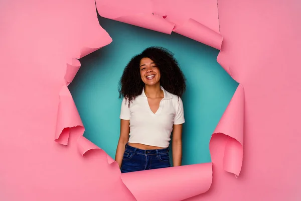 若いですアフリカ系アメリカ人女性で引き裂かれた紙に隔離された青の背景幸せな笑顔と陽気 — ストック写真