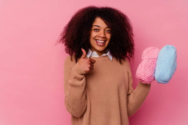 若いですアフリカ系アメリカ人女性を保持しています縫製糸隔離されたピンクの背景笑顔と上げ親指アップ — ストック写真