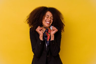 Genç Afrikalı Amerikalı hostes sarı arka planda izole edilmiş mutlu ve başarılı hissediyordu. Zafer konsepti.