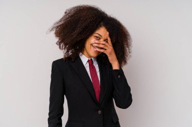Beyaz arka planda izole edilmiş takım elbiseli genç Afrikalı Amerikalı iş kadını parmaklarıyla kameraya göz kırpıyor, yüzünü kapatmaktan utanıyor..
