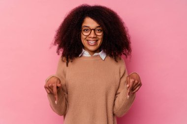 Genç Afrikalı Amerikalı kadın pembe arka planda izole edilmiş parmakları aşağıda, pozitif bir duygu..