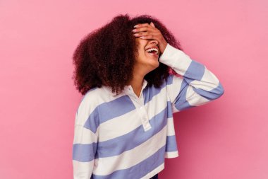 Pembe arka planda izole edilmiş genç Afro-Amerikalı kadın mutlu bir şekilde ellerini başının üstünde tutarak gülüyor. Mutluluk kavramı.