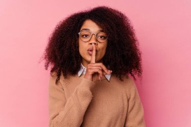 Genç Afrikalı Amerikalı kadın pembe arka planda izole edilmiş bir şekilde sır saklıyor ya da sessizlik istiyor..